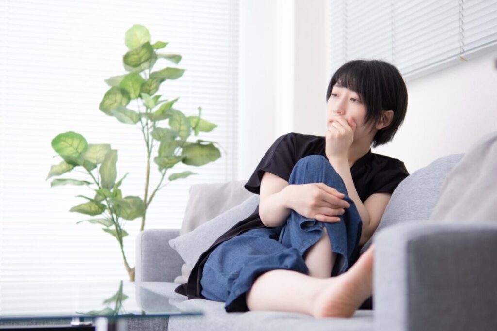 部屋で一点を見つめている女性